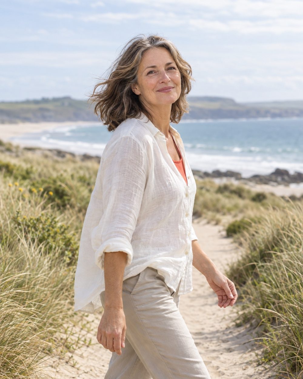 A woman enjoying a bright coastal walk